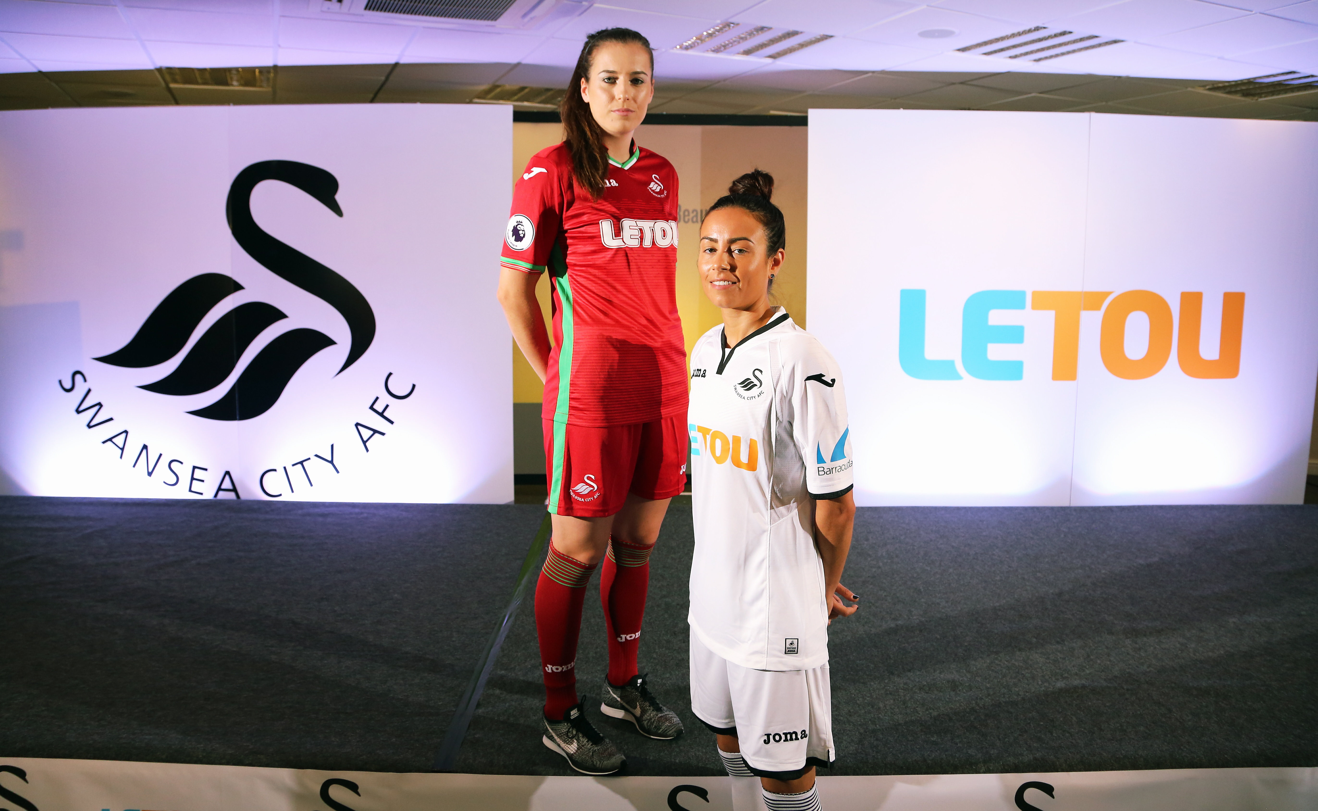 Pictured: Katy Hosford (RED) and Alicia Powe (WHITE) of the Swansea City FC Ladies' team model the home and away kits. Monday 19 June 2017 Re: Swansea City FC launch their new home and away kits and announce Letou as their new sponsor at the Liberty Stadium, Swansea, Wales, UK.