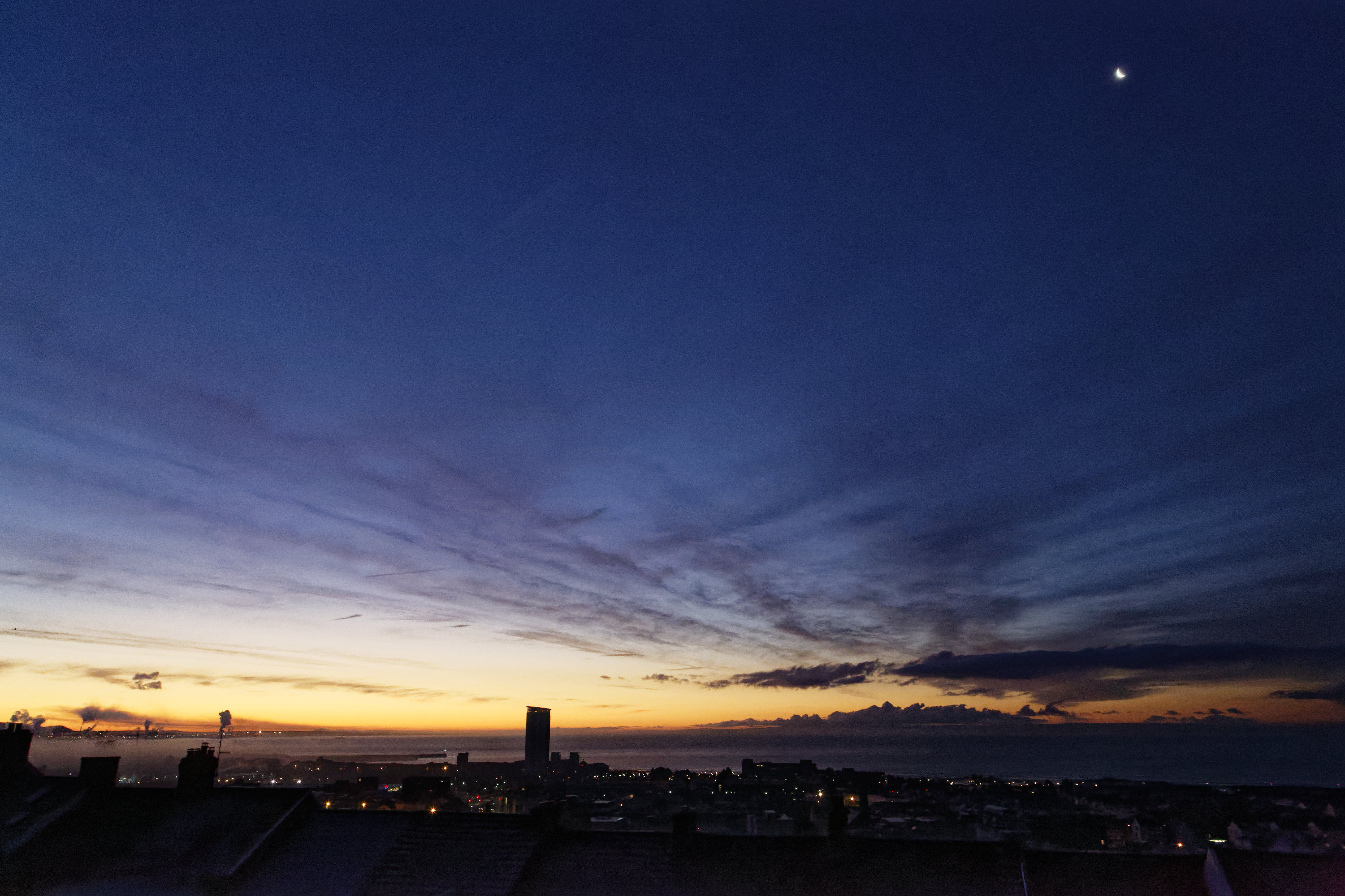 WEATHER PICTURE WALES A crescent moon is still visible in the clear sky over roof tops during an early frosty morning in Swansea, Wales, UK. Tuesday 12 December 2017