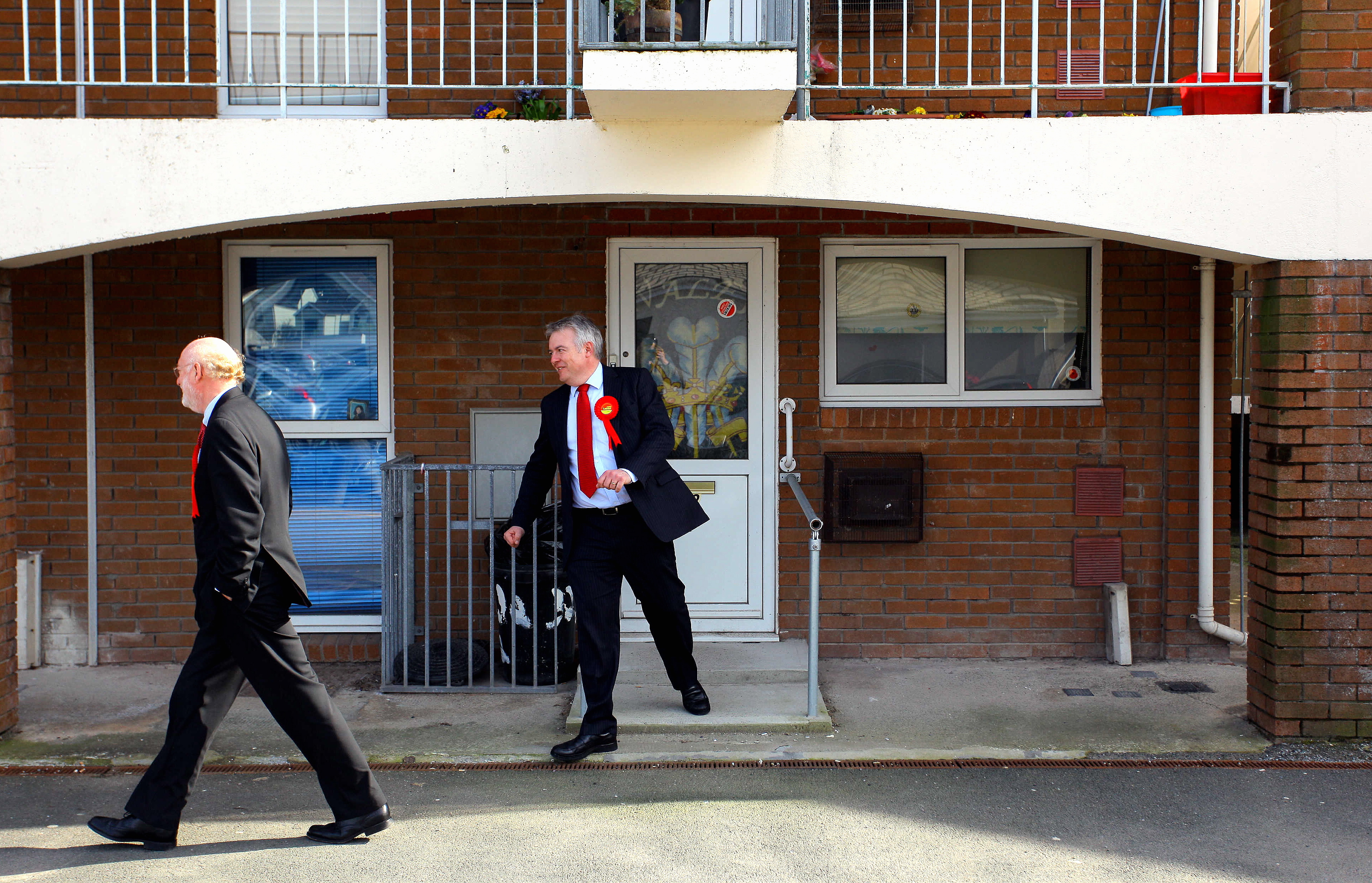 Pictured: Carwyn Jones (R) with Nick Ainger (L) coming out of a flat they just canvassed Re: First Minister for Wales Carwyn Jones canvassing in Carmarthen west Wales with Nick Ainger. Thursday 08 April 2010