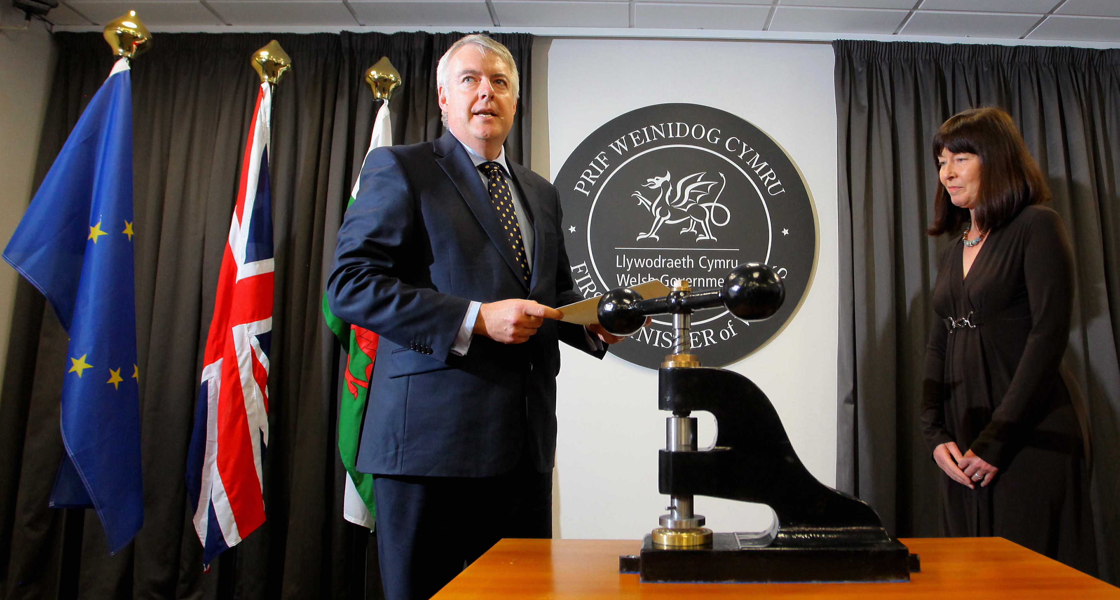 Monday 12 November 2012 Pictured L-R: First Minster for Wales Carwyn Jones hands over the sealed document to Claire Clancy Clerk of the Assembly at the Welsh Government in Cardiff, south Wales. Re: The first bill passed by the Welsh assembly since last year's referendum on its powers has become law at a ceremony in Cardiff. First Minister Carwyn Jones has fixed an official seal to documents signed by the Queen giving Royal Assent to the Official Languages Bill. It is the first time the ceremony has happened since the assembly acquired direct law-making powers in May 2011. Mr Jones said it was a "historic" occasion. The bill became law when the first minister applied the seal and handed it to the clerk of the assembly. Drawn up by the assembly's own authorities, the measure is designed to give equal status to the Welsh and English languages in the assembly. The assembly has also approved legislation to reform the way local bye-laws are made, but it was challenged in the supreme court by the UK government before it could become law. Mr Jones said: "Today is a historic day for us as a nation. It heralds the beginning of a new era for the governance of Wales."